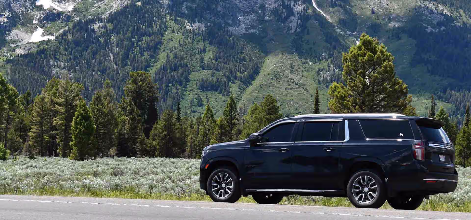 Black SUV car service on a snowy road near a Vermont ski resort