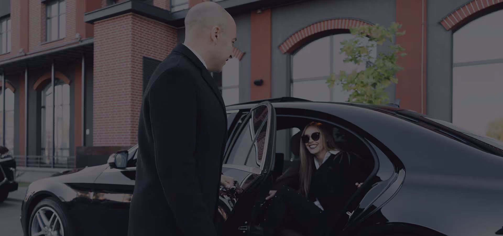 Professional limousine Chauffeur waiting for a corporate client next to a luxury limo in Bristol, RI